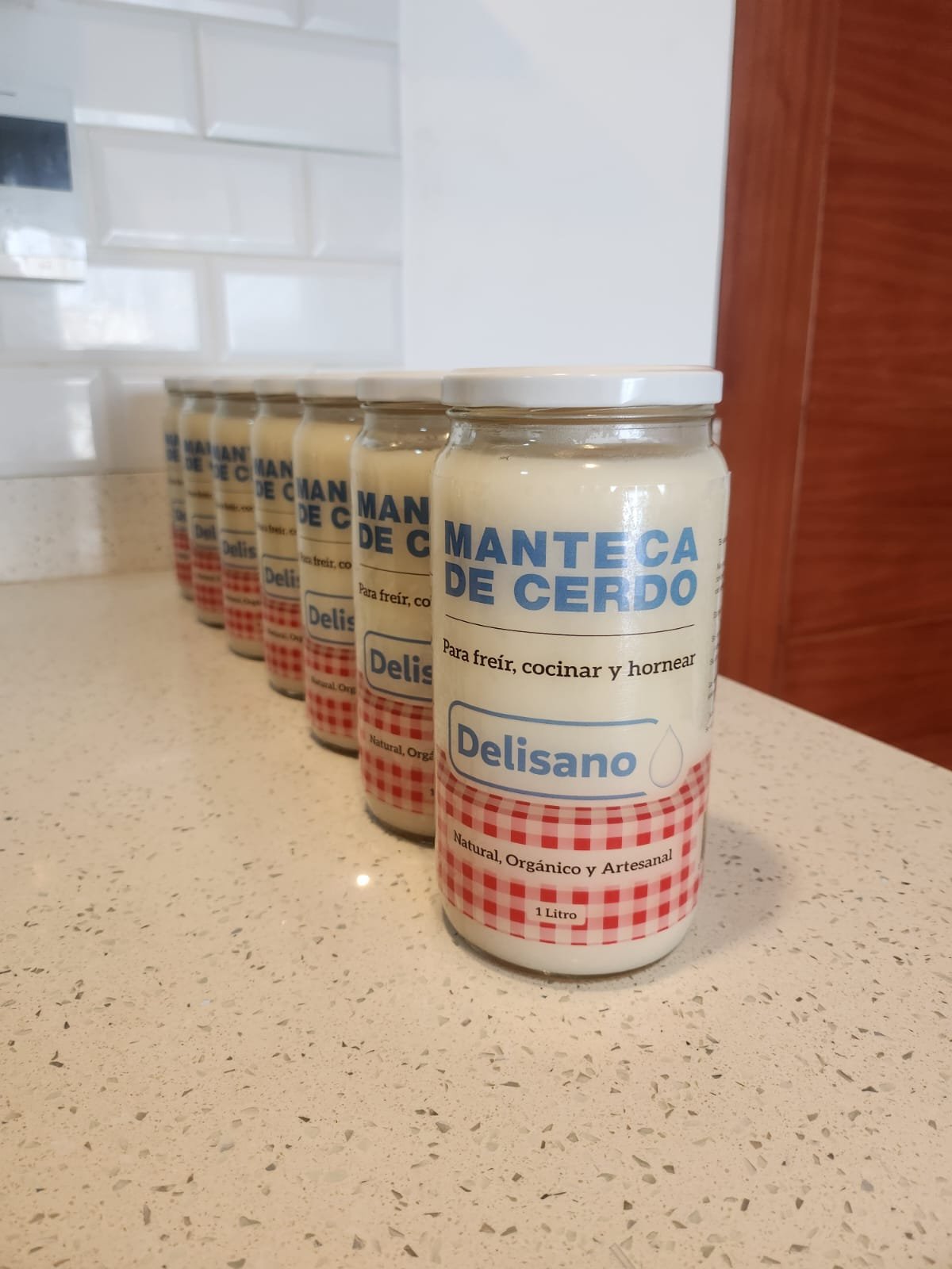 Frascos de manteca de cerdo Delisano en fila sobre el mostrador